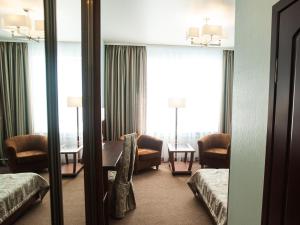 a hotel room with a living room with a mirror at Hotel Slavyanskaya in Tambov