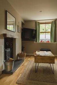 uma sala de estar com uma mesa e uma lareira em Crossroads Cottage em Drumnadrochit
