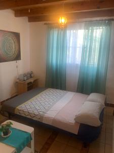 1 dormitorio con 1 cama grande y cortinas azules en Majada Blanca en Antigua