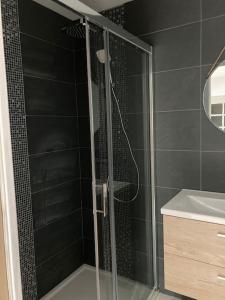 W łazience znajduje się prysznic ze szklanymi drzwiami. w obiekcie La p’tite maison de locqui w mieście Locquirec