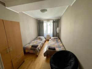 a room with two beds and a chair in it at Apartamenty nad jeziorem - 4 in Ełk