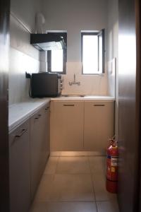 a small kitchen with a sink and two windows at Hotel Ballas in Agria