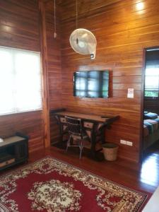 Habitación con mesa en una habitación con paredes de madera. en Golden Teak Resort Baan Sapparot, en Kamala Beach