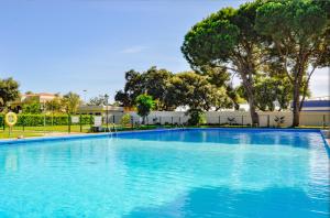 een groot blauw zwembad met bomen op de achtergrond bij Bright & Modern 2 Bedroom Apartment 300m to the Beach - Marbella in Marbella