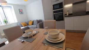 a kitchen and dining room with a wooden table with dishes on it at Treasured 1 Bedroom Jewellery Quarter Apartment in Birmingham