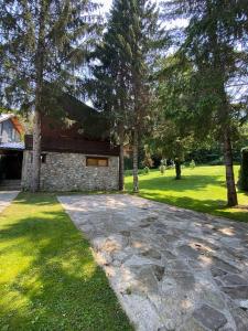 a stone driveway in front of a house with trees at Brezovica Luxury Villa in Brezovica