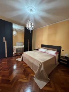 ein Schlafzimmer mit einem großen Bett und einem Kronleuchter in der Unterkunft Malies B&B in Benevento