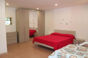 明图尔诺Lido Villaggio il Ragno的一间卧室配有红色的床和镜子