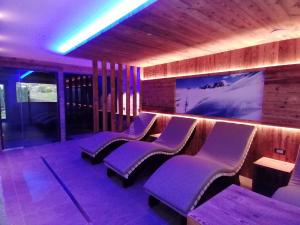 a bar with purple chairs and a wall with a mural at DOLOMITES B&B - Suites, Apartments and SPA in Tesero