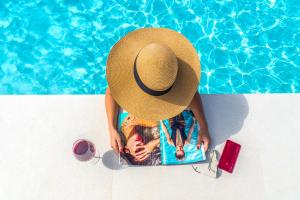 a person wearing a straw hat next to a swimming pool at Villa Florentina ✩ Private Pool ✩ BBQ ✩ 7 Guests in Alikianós