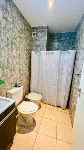 a bathroom with a toilet and a shower and a sink at Departamentos "La Perla" in Andalgalá +63 photos