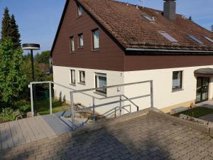 uma grande casa com um telhado castanho e uma escadaria em Roter Beer em Sankt Andreasberg