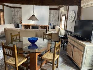 a living room with a glass table and a tv at La Perera - Alojamiento turístico in La Perera