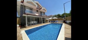 a house with a swimming pool in front of a house at Villa Sunset in Dalyan