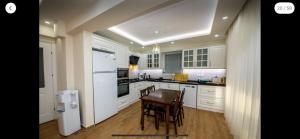a kitchen with white cabinets and a table and chairs at Villa Sunset in Dalyan