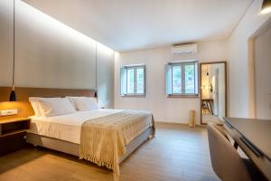 a bedroom with a bed and a desk and windows at Armantanis Luxury Suites in Areopoli