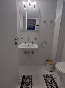 een witte badkamer met een wastafel en een toilet bij THE LOFT PROJECT BY DIMITROPOULOS in Aigio