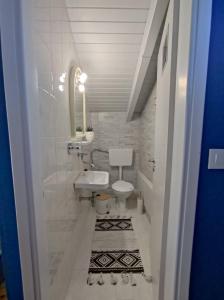 La salle de bains blanche est pourvue d'un lavabo et de toilettes. dans l'établissement THE LOFT PROJECT BY DIMITROPOULOS, à Aigio