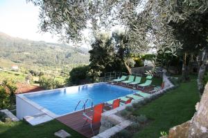 a swimming pool with a bunch of chairs around it at As Casinhas de Loureda in Arcos de Valdevez