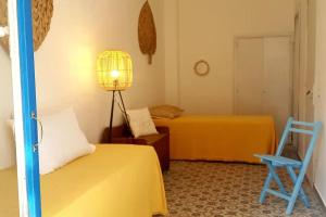 1 dormitorio con 2 camas, lámpara y silla en Casaammari, en Acireale