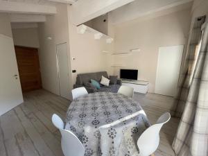 ラ・サルにあるAppartamento Maison Blancheのリビングルーム(テーブル、椅子、ソファ付)