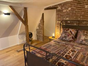 a bedroom with a bed and a brick wall at Loft in der alten Spinnerei in Spechtholzhock