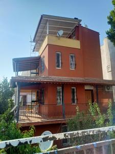 una casa roja con un balcón en el lateral. en Villa en Kusadası