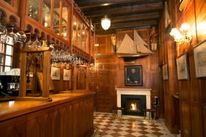 a bar with a fireplace in a room with wooden walls at Hotel Ateneo Sevilla in Seville