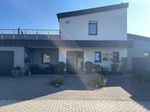 a large white house with a courtyard in front of it at #NEU l Seeblick l NETFLIX l BOXSPRING l NESPRESSO l e-TÜR l Terrasse l 82m2 in Ulmen +12 photos