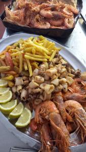 un plato de comida con marisco y patatas fritas en Hotel Milanesina, en Alassio