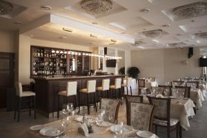 restauracja ze stołami i krzesłami oraz bar w obiekcie Victoria Hotel na Zamkovoy Minsk w Mińsku