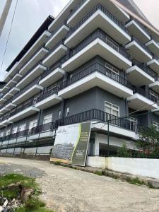 a large apartment building with a sign in front of it at THE WIND LILY - Lake View Luxury Apartment in Nuwara Eliya