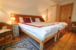 a bedroom with a large bed with a wooden headboard at Lough Dan House in Oldbridge