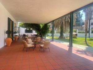 un patio con tavolo, sedie e finestre di Viña Femita a Villafranca del Bierzo