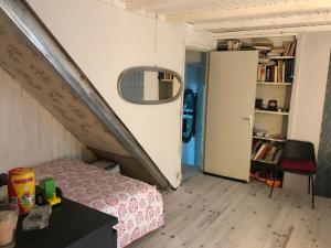 ein kleines Schlafzimmer mit einem Bett und einer Treppe in der Unterkunft Treacy’s résidence in Morez