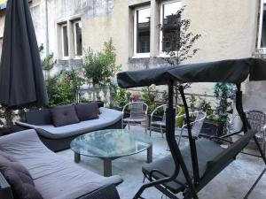une terrasse avec une table, des chaises et un parasol dans l'établissement Treacy’s résidence, à Morez