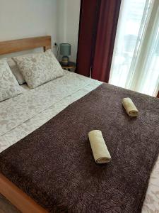 a bedroom with a bed with two towels on it at Apartman Miss T in Podgorica