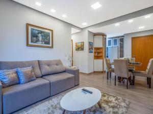 un salon avec un canapé et une table dans l'établissement Casa de Pedra - 301D - Apto com piscina em Gramado, à Gramado
