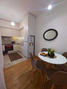 uma cozinha com mesa e cadeiras num quarto em Apartman Miss T em Podgorica