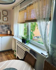 a kitchen with a window and a table and chairs at Apartament Ad Astra in Dziwnów