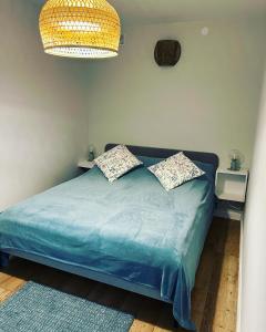 a bedroom with a blue bed with two pillows at Apartament Ad Astra in Dziwnów