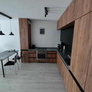 a kitchen with black counters and a table at Apartament na Malczewskiego in Międzyrzecz