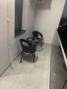 two chairs and a table in a room with a window at Serin Blaxy Studio in Mangalia