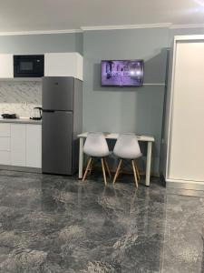 a kitchen with two chairs and a table and a refrigerator at Serin Blaxy Studio in Mangalia
