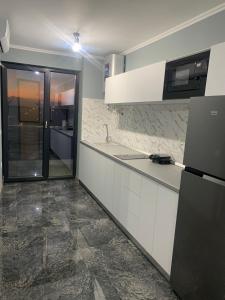 a kitchen with white cabinets and a counter top at Serin Blaxy Studio in Mangalia