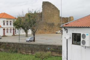 samochód zaparkowany przed dużym budynku z cegły w obiekcie Alojamento Local Santa Cruz w mieście Miranda do Douro