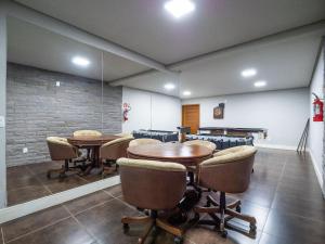 une salle de conférence avec des tables et des chaises dans l'établissement Casa de Pedra - 301D - Apto com piscina em Gramado, à Gramado 50 autres photos