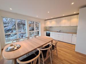 a large kitchen with a wooden table and chairs at Ropeid Villa Fjordferie in Ropeid