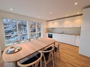 a large kitchen with a wooden table and chairs at Ropeid Villa Fjordferie in Ropeid +24 photos