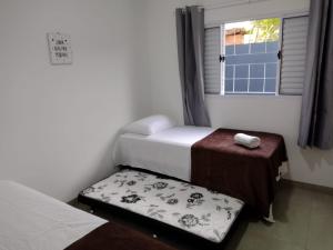 a small room with two beds and a window at Casa Premium em Bonito - Linda e Confortável in Bonito